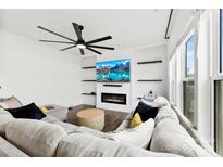 Cozy living room features an electric fireplace, TV, modern ceiling fan and comfortable seating at 1976 Ethan Ln, Stanfield, NC 28163