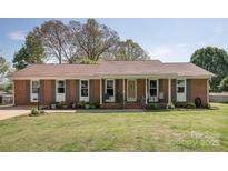 Charming brick ranch-style home with well-maintained lawn and landscaping, featuring a covered front porch at 2064 Elizabeth Ave, Hickory, NC 28602