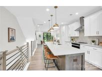 Bright, modern kitchen with stainless steel appliances, large island, and pendant lighting at 3441 Byrnes St, Charlotte, NC 28205