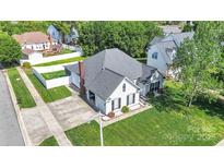 Charming white home featuring a driveway, garage and a well manicured lawn and fenced backyard at 3701 Arthur St, Indian Trail, NC 28079