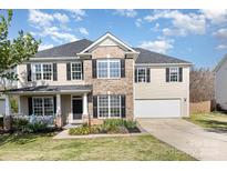 Charming two-story home with a brick facade, covered porch, well-manicured lawn, and an attached two-car garage at 4001 Brook Valley Run, Monroe, NC 28110