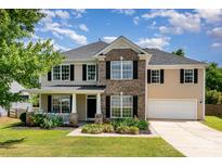 Beautiful two-story home with a well-manicured lawn, charming front porch, and attached two-car garage at 4001 Brook Valley Run, Monroe, NC 28110