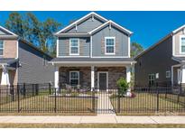 Charming two-story home features a stone facade, black fence, and landscaped front yard at 504 Cranford Dr, Pineville, NC 28134