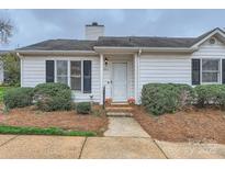 Charming single-story home with a white exterior, complemented by manicured landscaping and a welcoming front door at 5913 Crape Myrtle Ln, Charlotte, NC 28216