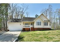 Charming one-story home with a well-manicured lawn, attached garage, and inviting front porch at 623 Roxboro Dr, Mount Gilead, NC 27306