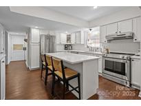 Bright kitchen with stainless steel appliances, quartz countertops and a large island at 6807 Stoney Ridge Rd, Matthews, NC 28104