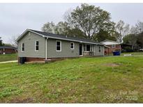 View of the home's exterior, featuring vinyl siding and a well-maintained lawn at 8124 Wood St, Mount Pleasant, NC 28124