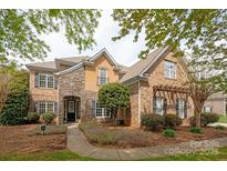 Charming two-story home with a combination of brick, stone, and stucco facade, and well-manicured landscaping at 11308 Wheat Ridge Rd, Charlotte, NC 28277