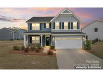 Charming two-story home with a manicured lawn and a two-car garage at 1409 Augustus Beamon Dr, Indian Trail, NC 28079