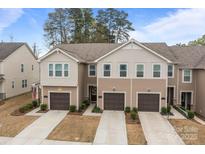 Charming townhome showcasing a well-manicured lawn, attached garages, and a welcoming two-story facade at 16038 Red Buckeye Ln, Huntersville, NC 28078