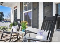 Inviting front porch with rocking chairs, decorative pillows, and a quaint table with flowers at 2363 Shanklin S Ln, Denver, NC 28037