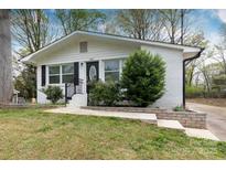 Charming home featuring a brick exterior and landscaped front yard with lush greenery and inviting curb appeal at 2408 Dora Dr, Charlotte, NC 28215