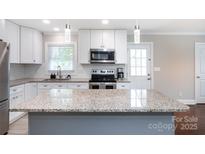 Modern kitchen with granite countertops, stainless steel appliances, and white cabinetry at 2408 Dora Dr, Charlotte, NC 28215