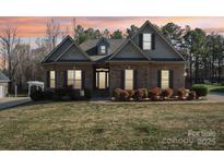 Charming brick home featuring a manicured lawn and mature landscaping at 304 Wintergreen Ct, Kings Mountain, NC 28086