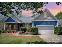 Charming home featuring stone accents, blue siding, a well-manicured lawn and an attached two-car garage at 3846 Bent Creek Sw Dr # 58, Concord, NC 28027