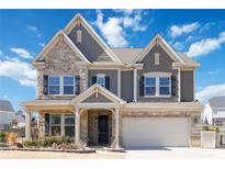 Charming two-story home featuring stone accents, a covered porch, and an attached two-car garage at 4519 Waylon Ave, Fort Mill, SC 29715