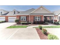 Inviting brick home featuring manicured landscaping and an attached two-car garage at 8518 Christalina Ln, Denver, NC 28037