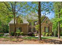 Stunning stone and brick home with lush landscaping and mature trees at 12627 Ninebark Trl, Charlotte, NC 28278