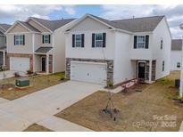 Charming two-story home with white siding, stone accents, a two-car garage, and a well-maintained lawn at 14217 Wilson Mac Ln, Charlotte, NC 28278