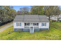 Charming single-story home featuring blue shutters, a covered front porch, and a well-maintained lawn at 2420 Kannapolis Hwy, Concord, NC 28027