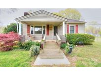 Charming single-story home with a cozy front porch and lush landscaping at 2453 Myrtle Ave, Gastonia, NC 28052