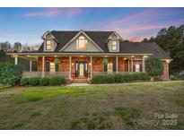 Charming brick home with a welcoming front porch and beautifully landscaped front yard at 361 Nance Rd, Stanfield, NC 28163
