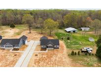Expansive aerial view of a new home build, showcasing the surrounding wooded acreage and outbuildings at 3957 Miller Rd, Salisbury, NC 28147