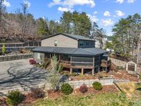 Spacious home with a large deck, well-maintained landscaping, and mature trees at 466 Shoreline Rd, New London, NC 28127
