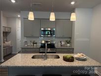 Modern kitchen featuring gray cabinets, stainless steel appliances, granite countertops, and pendant lighting at 5103 Orchardview Way # 27, Charlotte, NC 28216