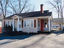 Charming single-story home featuring a quaint front porch, covered carport, and a well-maintained yard at 58 Kentucky Sw Ave, Concord, NC 28027