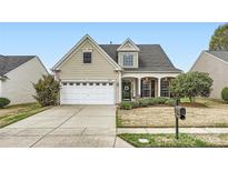 Charming home featuring a two-car garage, well-maintained lawn, and classic architectural details at 8812 Heron Glen Dr, Charlotte, NC 28269