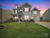 Charming two-story home with a well-manicured lawn and a two-car garage, showcasing its inviting curb appeal at 9582 Creighton Nw Rd, Concord, NC 28027