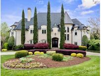 Stately home featuring a landscaped front yard, manicured bushes and tall evergreen trees at 11236 Mcclure Manor Dr, Charlotte, NC 28277