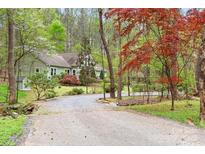 Charming home nestled among trees, featuring a gravel driveway and lush landscaping for a serene and private setting at 113 Duval Ct, Mooresville, NC 28117