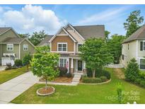 Charming two-story home with a manicured lawn, mature trees, and inviting front entrance at 1224 Screech Owl Rd, Waxhaw, NC 28173