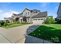 Charming two-story home with a well-manicured lawn, concrete driveway, and an attached two-car garage at 1255 Fishing Creek Rd, Clover, SC 29710