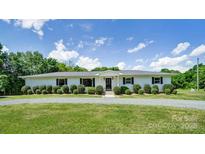 Charming ranch-style home featuring manicured lawn and mature landscaping on a sunny day at 12842 Plaza Road Ext, Charlotte, NC 28215