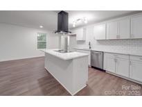 A modern kitchen features an island, stainless steel appliances, and crisp white cabinetry at 129 Wilson St, Chester, SC 29706