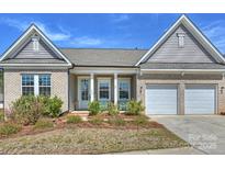 Charming brick home featuring a two-car garage, well-kept landscaping, and a welcoming front porch at 152 Amerson Dr, Rock Hill, SC 29730