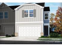 Beautiful two-story home showcasing a light gray exterior, white garage door, and manicured front yard at 1716 Braemar Village Dr, Monroe, NC 28110