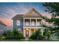 Charming two-story home boasts a welcoming porch and manicured lawn, perfect for suburban living at 3013 Kensley Dr, Waxhaw, NC 28173