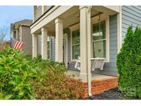 Inviting front porch with swing and beautiful landscaping at 3013 Kensley Dr, Waxhaw, NC 28173