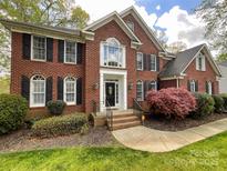 Beautiful brick home with a manicured lawn, lush landscaping and black window shutters create curb appeal at 6114 Abergele Ln, Matthews, NC 28104