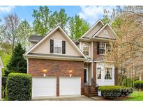 Charming two-story home featuring a brick facade and a two-car garage and manicured landscaping at 8619 Delamere Ln, Charlotte, NC 28269