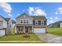 Charming two-story home featuring stone accents, a two-car garage, and a well-manicured lawn at 1526 Cottage Creek Dr, Bessemer City, NC 28016