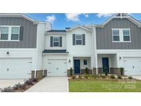 Charming townhome features a one-car garage, landscaped yard, and stylish gray and white color scheme at 1741 Braemar Village Dr, Monroe, NC 28110