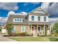 Charming two-story home featuring a stone facade, a lovely porch, and a neatly manicured front lawn at 2222 Smoltz Dr, Rock Hill, SC 29730