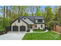 Charming two-story home with white brick, black accents, two-car garage, and manicured lawn at 3038 Northampton Dr, Charlotte, NC 28210