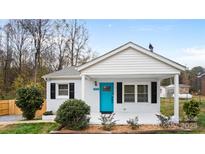 Charming home featuring a blue front door, white painted brick, and a cozy front porch at 318 Lake Montonia Rd, Kings Mountain, NC 28086