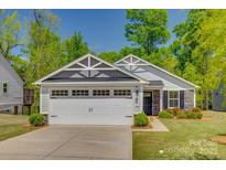 Charming single-story home with a two car garage, stone accents, and manicured lawn at 4503 Hunton Dale Nw Rd, Concord, NC 28027